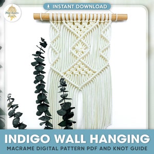 May include: White macrame wall hanging with a geometric pattern. The hanging is attached to a wooden dowel rod. The hanging is in front of a white background.