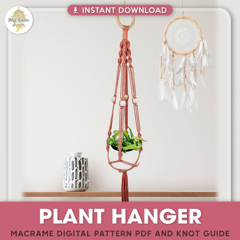 Puede incluir: Un macetero de macram&eacute; rosa con cuentas de madera y un borla. El macetero est&aacute; colgado de un anillo de madera y sostiene una peque&ntilde;a planta en maceta. La imagen incluye el texto "PLANT HANGER" y "MACRAME DIGITAL PATTERN PDF AND KNOT GUIDE".