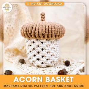 May include: A macrame acorn-shaped basket with a brown top and a white woven body. The basket has a textured appearance. The image also includes the text "ACORN BASKET" and "MACRAME DIGITAL PATTERN PDF AND KNOT GUIDE".