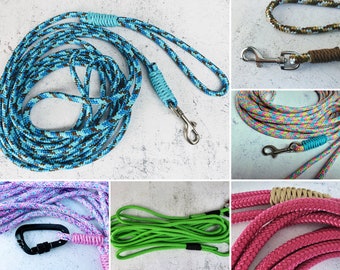 May include: Assortment of colorful rope dog leashes with different colored clasps. The leashes are made of braided rope and come in a variety of colors, including blue, green, pink, and brown.