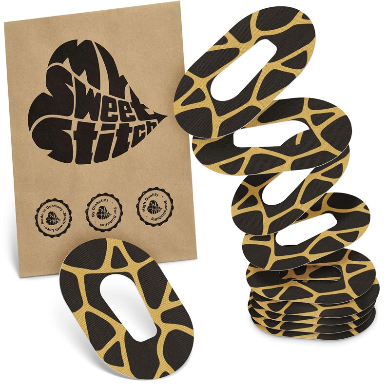 May include: Black and gold oval patches with a giraffe print pattern are stacked on a white background. A brown paper packet with the text "Sweet Stitch" in a heart shape is on the left. The packet has three small circular logos.