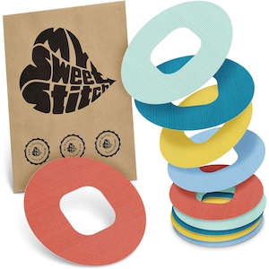 May include: A collection of colourful, textured, oval-shaped medical patches in shades of red, blue, yellow, and teal. A brown paper bag with the text "My Sweet Stitch" and three circular seals is in the background.