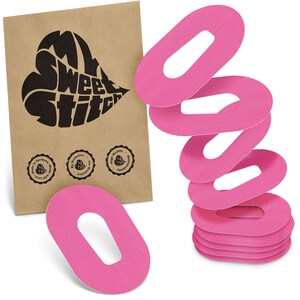 May include: A collection of pink, oval medical patches with a central aperture, alongside a brown paper bag. The bag displays a heart-shaped logo with the words "My Sweet Stitch" and several circular seals with text.