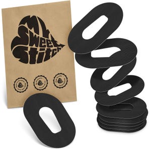 May include: Black, oval-shaped adhesive patches with a white centre, stacked beside a brown paper package. The package displays a heart-shaped logo with the text "My Sweet Stitch" and three circular seals.