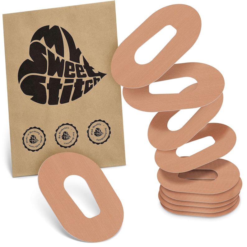 May include: A collection of tan oval medical patches with a central aperture, alongside a brown paper packet. The packet displays a black heart-shaped logo with the text "Sweet Stitch" and three circular seals.