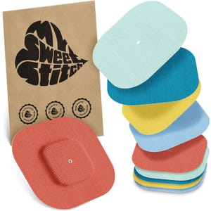 May include: A stack of colorful, rectangular pads in shades of blue, yellow, and red, with a textured surface. A brown paper bag with the text "My Sweet Stitch" and three small circular logos is in the background. The pads appear to be medical or therapeutic.