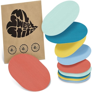 Può includere: Un mucchio di solette ovali multicolori, in tonalità di blu, giallo e rosso, accanto a un sacchetto di carta marrone con la scritta "My Sweet Stitch" a forma di cuore. Le solette sono strutturate.