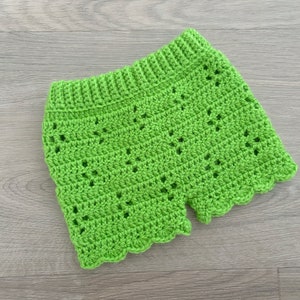 Op de afbeelding: Limoengroene gehaakte shorts met een gegolfde zoom. De shorts zijn gemaakt met een delicaat open steekpatroon.