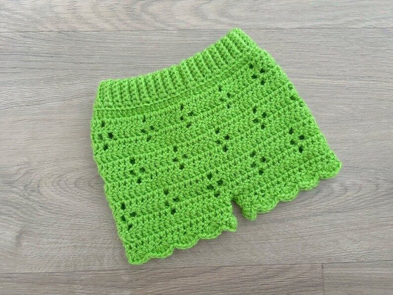 Op de afbeelding: Limoengroene gehaakte shorts met een gegolfde zoom. De shorts zijn gemaakt met een delicaat open steekpatroon.