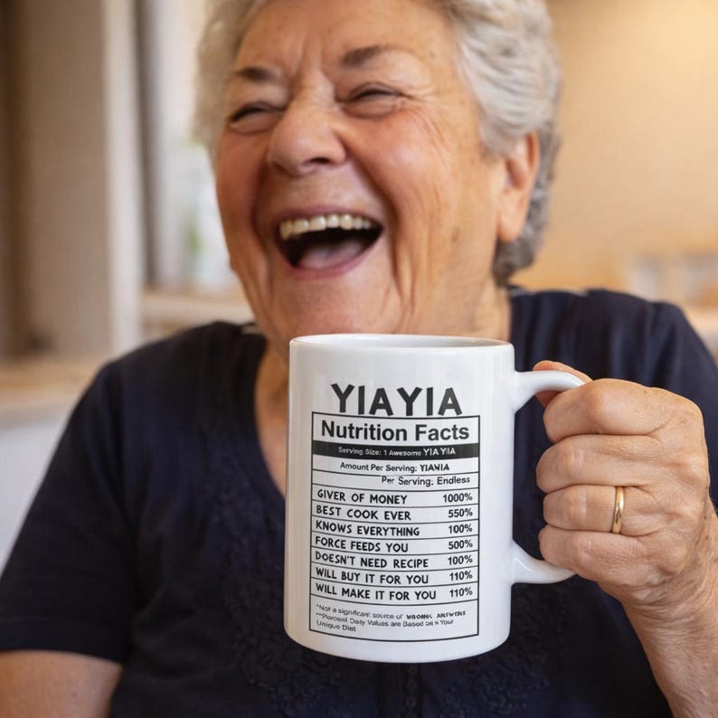 May include: A white ceramic mug featuring black text titled YIAYIA Nutrition Facts. The label lists attributes including Giver of Money 1000%, Best Cook Ever 550%, Knows Everything 100%, Force Feeds You 500%, Doesn't Need Recipe 100%, and Will Buy It For You 110%.