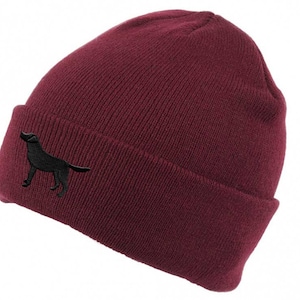 May include: A burgundy beanie with a black embroidered silhouette of a dog on the side.