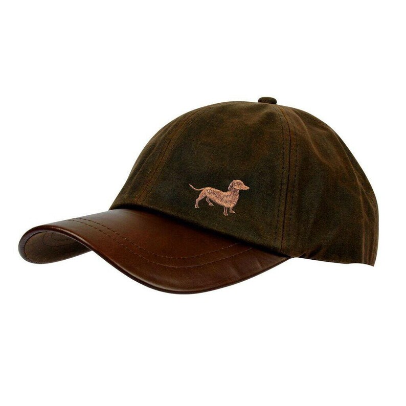 May include: A brown waxed cotton baseball cap with a brown leather brim. The cap has an embroidered dachshund on the front.