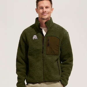 May include: A green fleece jacket with a zipper closure and a small embroidered dog on the left chest. The jacket has a dark green patch pocket on the left side.