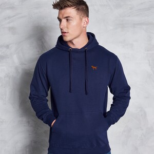 May include: A navy blue hooded sweatshirt with a small brown dog logo on the left chest. The sweatshirt has a kangaroo pocket and a drawstring hood.