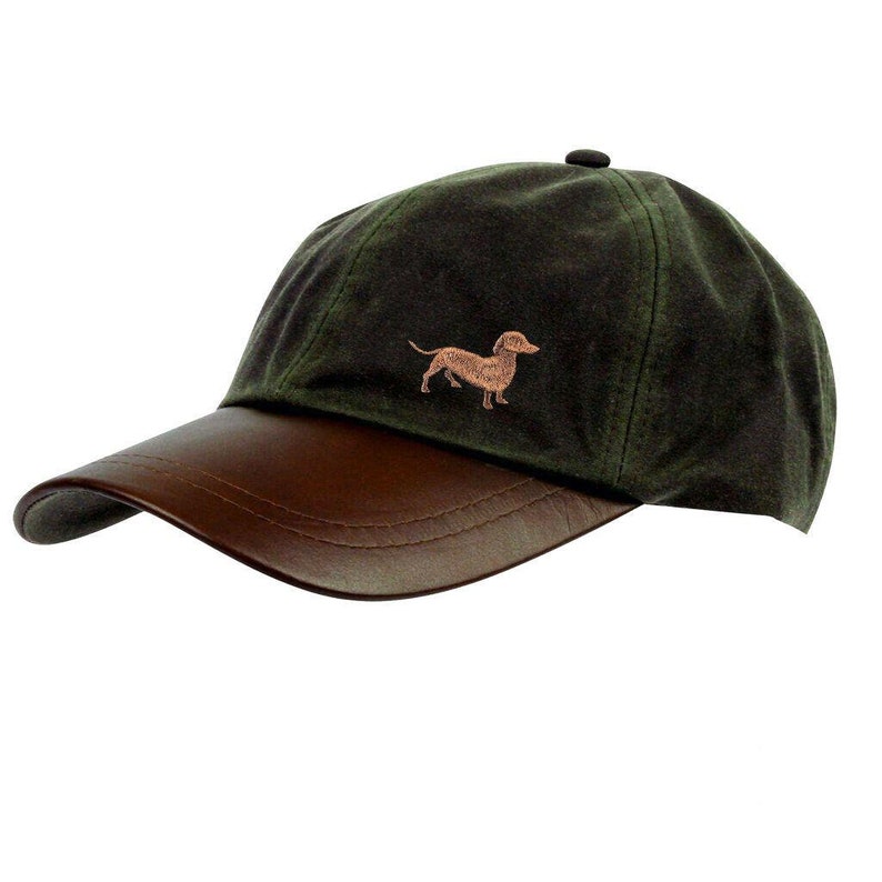 May include: A green and brown baseball cap with a leather brim and an embroidered dachshund on the front.