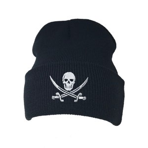 Puede incluir: Un gorro de punto negro con un diseño de calavera y huesos cruzados bordados en blanco.