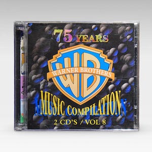 Può includere: Una custodia per CD nera con il logo Warner Brothers e il testo "75 Years Warner Brothers Music Compilation 2 CD's/Vol 8". Lo sfondo è nero con un motivo di piccoli cerchi blu e bianchi.