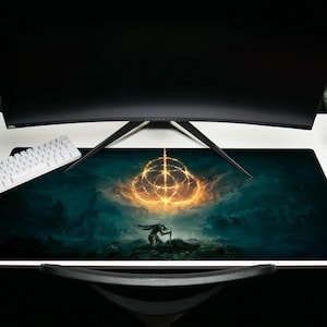 K&ouml;nnte beinhalten: Ein gro&szlig;es rechteckiges Gaming-Mauspad mit einer Fantasy-Landschaft mit einem leuchtenden goldenen Symbol und einer Silhouette. Das Pad ist &uuml;berwiegend t&uuml;rkis und schwarz, mit einer wei&szlig;en Tastatur und einem schwarzen Monitor im Hintergrund.