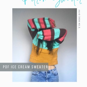 Puede incluir: Un suéter de crochet con un patrón a rayas en marrón, rosa y turquesa. El suéter es de estilo corto y tiene una sección inferior amarilla. El texto "PDF ICE CREAM SWEATER" está en la parte inferior de la imagen.