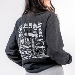 May include: A dark gray sweatshirt with white text on the back. The text includes the word "NURSE" and phrases like "You did your best", "Fill your cup first", "Remember your why", and "You are exactly where you should be".