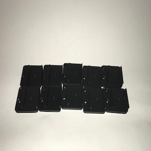 May include: Ten black plastic mounting brackets with screw holes.