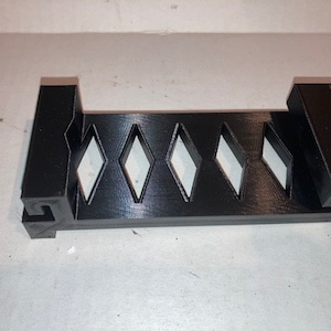 May include: Black plastic organizer with five diamond-shaped compartments.