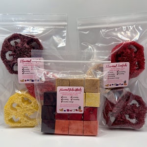 May include: Three clear plastic bags filled with colorful, natural, flavored snacks for small pets. The bags contain a variety of shapes and sizes of loofah and blocks. The loofah is red and yellow. The blocks are red, orange, and yellow. The bags are labeled "Flavored Loofahs" and "Flavored Baba Blocks".