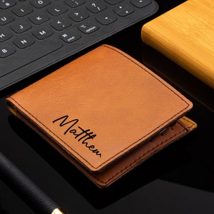 Puede incluir: Una cartera de cuero marr&oacute;n con el nombre "Matthew" grabado en la parte delantera.