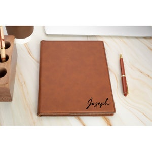 May include: A brown leatherette journal with the name "Joseph" engraved on the front.