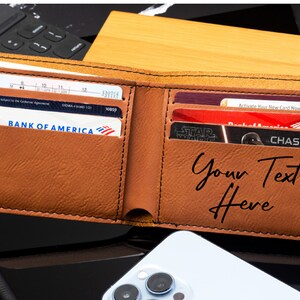 Puede incluir: Una cartera de cuero marr&oacute;n con m&uacute;ltiples ranuras para tarjetas y una inscripci&oacute;n personalizada que dice "Your Text Here".