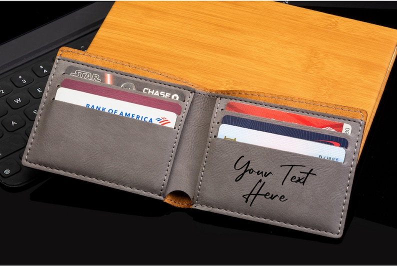 May include: A gray leather wallet with multiple card slots. The wallet is open and has several credit cards inside. The text "Your Text Here" is embossed on the inside of the wallet.