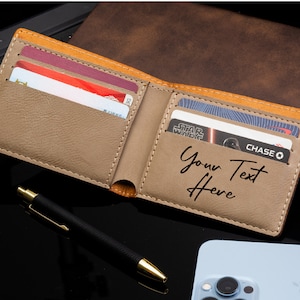 Puede incluir: Una cartera de cuero marr&oacute;n con ribete beige y una inscripci&oacute;n personalizada que dice "Your Text Here". La cartera est&aacute; abierta y tiene varias tarjetas de cr&eacute;dito en su interior.