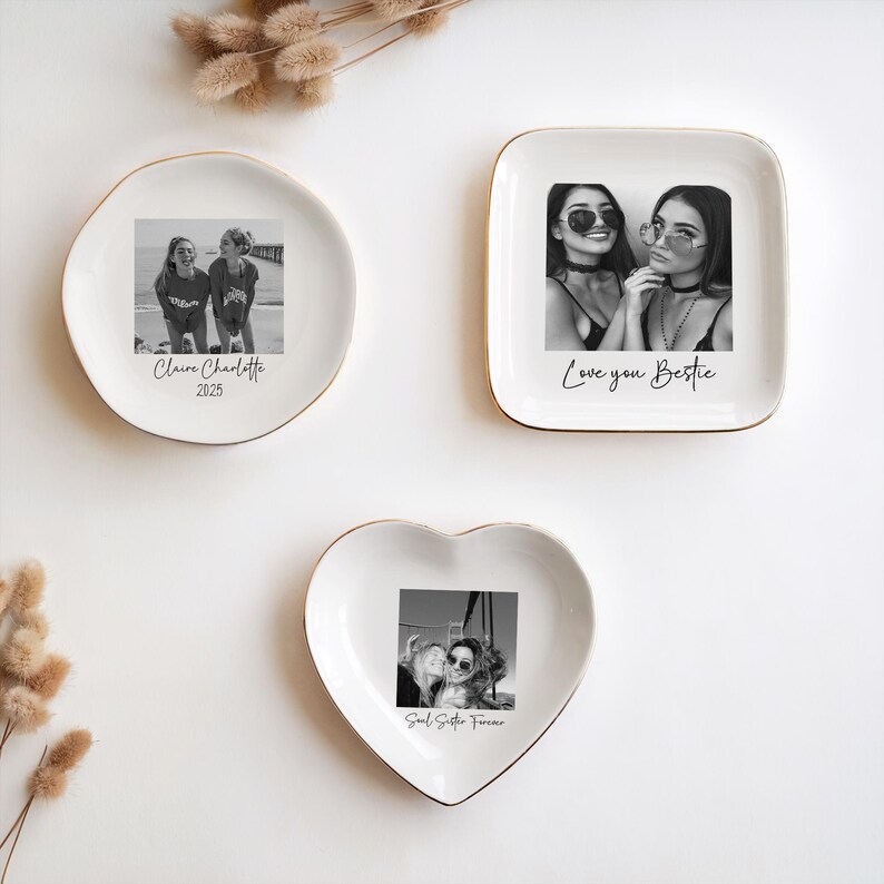May include: Three white ceramic trinket dishes with gold rims. Each dish features a black and white photograph. One is round, one square, and one heart-shaped. Text on the dishes reads "Claire Charlotte 2025", "Love you Bestie", and "Soul Sister Forever".