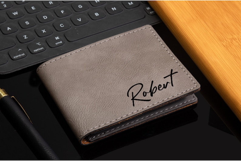 May include: A gray leather wallet with the name "Robert" embossed in black lettering.
