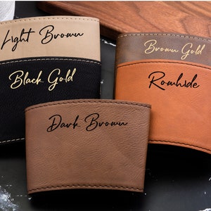 Puede incluir: Cuatro portavasos de cuero de diferentes colores con letras doradas. Los colores son marr&oacute;n claro, negro, marr&oacute;n dorado y marr&oacute;n oscuro. Las letras dicen "Light Brown", "Black Gold", "Brown Gold", y "Dark Brown".