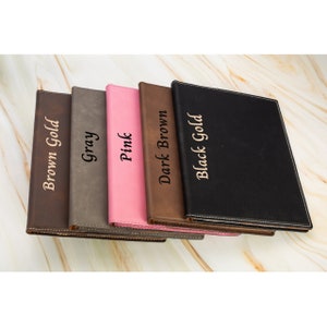 May include: Five leather-bound journals in different colors, including brown, gray, pink, dark brown, and black. Each journal has a gold inscription on the front cover, reading "Brown Gold", "Gray", "Pink", "Dark Brown", and "Black Gold" respectively.