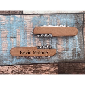 May include: A wooden handled pocket knife with a corkscrew and a personalized inscription that reads "Kevin Malone".