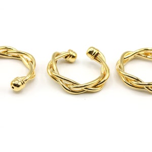 May include: Three gold-colored ear cuffs with a braided design. Each cuff has a rounded ball at each end. The ear cuffs are displayed on a white background.