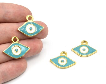 Puede incluir: Amuletos de metal dorado con forma de ojo, con fondo de esmalte turquesa y centro blanco y turquesa. Los amuletos tienen un pequeño lazo en la parte superior para sujetarlos a la joyería. Los amuletos miden aproximadamente 1,5 cm de ancho.