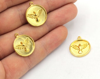 May include: Gold-colored round pendants with a raised image of a dove in flight. Each pendant has a small loop at the top for attaching to a chain or other jewelry component. The pendants are likely for jewelry making.