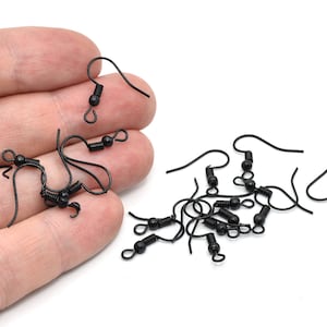 May include: Black earring hooks with a curved wire and a small coil spring. The hooks are made of metal and are designed for jewelry making. The hooks are shown against a white background.
