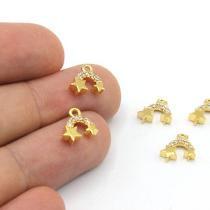 May include: Gold-coloured star charms with a curved bar of clear crystals. Each charm has two stars and a loop for attaching to jewellery. The charms are small and delicate, perfect for earrings or necklaces.