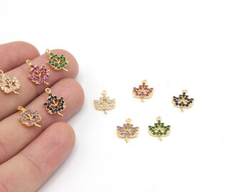 May include: Gold-toned leaf charms with colorful gemstone accents. The charms feature a leaf design with various colored stones, including clear, pink, green, blue, and purple. These charms are ideal for jewelry making and crafting.