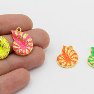 May include: Colorful enamel nautilus shell charms in neon yellow, hot pink, orange, and green with gold-colored trim. These pendants have a loop at the top for jewelry making. The shells are approximately 1 inch in length.