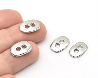 May include: Silver-colored oval buttons with two holes each. The buttons have a smooth, reflective surface and a rounded shape. These buttons are suitable for various sewing and crafting projects.