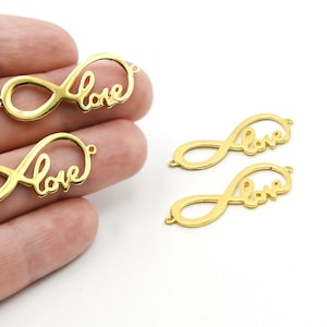 May include: Gold-colored metal charms in the shape of the infinity symbol with the word "love" scripted across the center. The charms have small loops on each end for attaching to jewelry or other crafts. Several charms are visible.