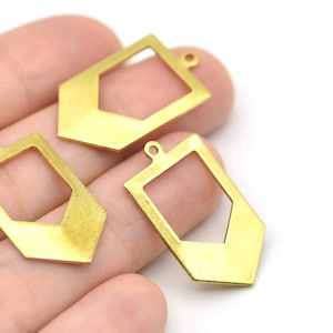 May include: Three gold-colored geometric pendants with a rectangular shape and a cutout design. Each pendant has a small loop at the top for attaching to a chain or other jewelry component. The pendants are shown against a white background.