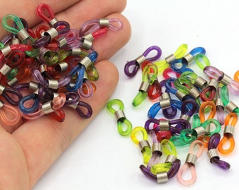 May include: A collection of colorful eyeglass retainers in various shades, including red, pink, green, blue, and purple. Each retainer features a clear, looped end and a silver-colored metal connector. The retainers are designed to hold eyeglasses.