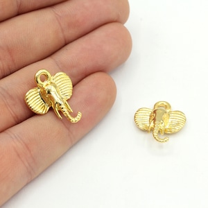 以下が含まれることがあります： 2つの金色の象のチャーム。各チャームは、大きな耳と丸まった鼻を持つ詳細な象の頭部が特徴です。チャームは小さく、ジュエリーやその他の工芸品に取り付けるためのループが付いています。