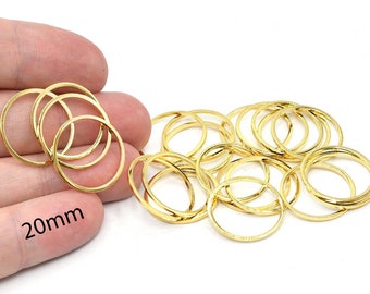 Puede incluir: Colección de abalorios dorados en forma de círculos abiertos. Los círculos miden aproximadamente 20 mm de diámetro. La imagen muestra varios círculos superpuestos. El fondo es blanco.